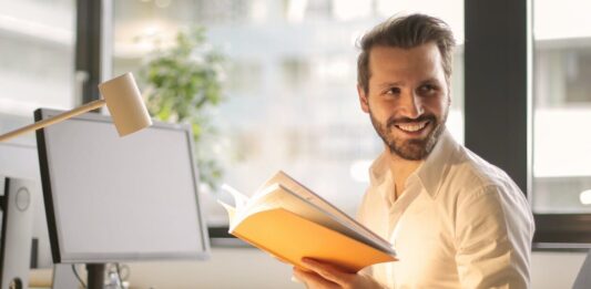 photo of man holding a book